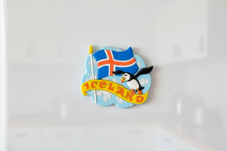 Fridge magnet with Icelandic flag and penguin on a white background