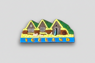 Decorative magnet of Icelandic houses with a person and text on a white background