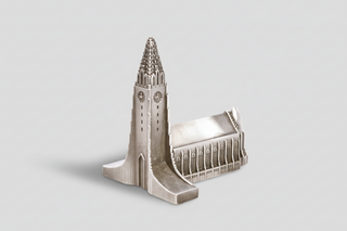 Model of a cathedral with a tall spire on a white background