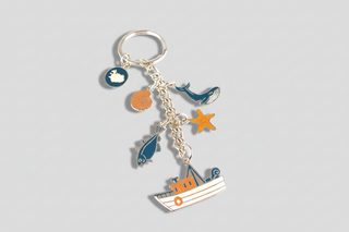 Metal Iceland souvenir keyring featuring marine life and fishing boat design