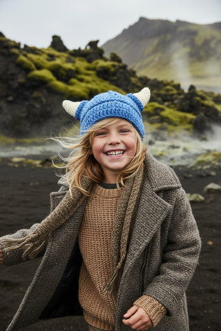 Blue knitted hat with white horns on a white background