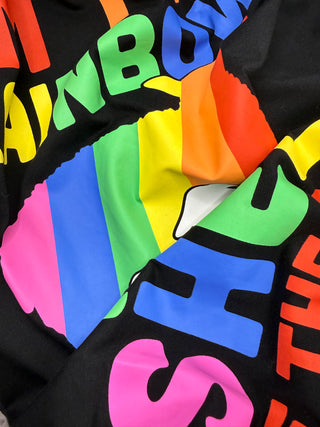 Close-up of a colorful fabric with rainbow text on a black background