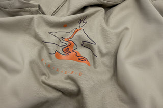 Close-up of a gray fabric with an orange and black abstract design.