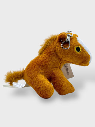 Plush horse keychain with a tag on a white background