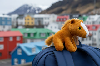 Plush horse keychain with a tag on a white background