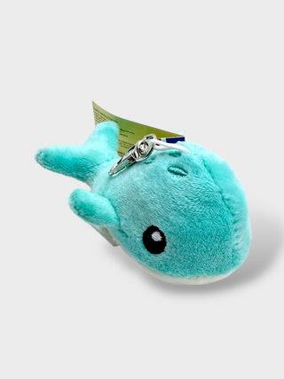 Plush toy whale with a keychain on a light gray background