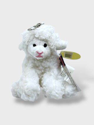 White plush lamb keychain with a tag on a light gray background