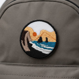 Embroidered patch with a mountain and wave design on a backpack 
