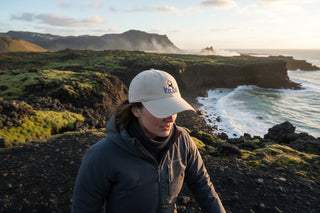 Beige cap with puffin design and 'Iceland' text on a light gray background