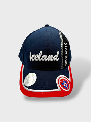 Navy and red baseball cap with embroidered “Iceland” text, Reykjavík detail, and Icelandic flag patch on the brim