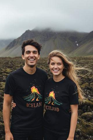 A black short-sleeve t-shirt with a graphic of an erupting volcano and the word 'ICELAND' printed on the front, displayed against a light gray background.
