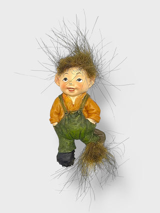 Cute Icelandic baby elf fridge magnet with fluffy wild hair, green overalls, and Nordic folklore-inspired design