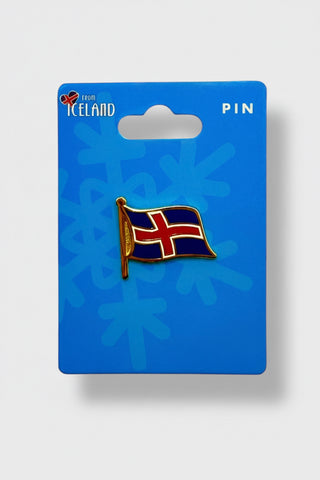 An Iceland flag enamel pin mounted on a blue backing card with 'Iceland' and 'PIN' printed on it, photographed against a light gray background.