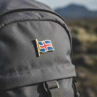Iceland Flag enamel lapel pin featuring the waving Icelandic flag on a blue souvenir display card