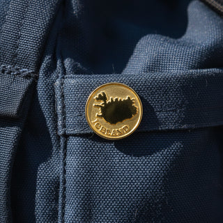 A gold-colored Iceland souvenir pin 