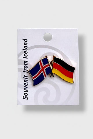 An enamel lapel pin depicting the flags of Iceland and Germany, mounted on a white backing card with the text 'Souvenir from Iceland' 