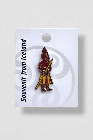 An enamel souvenir pin of a traditional Icelandic person with a spear, mounted on a white display card printed with 'Souvenir from Iceland'