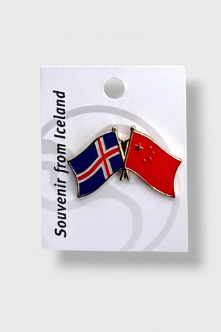 A souvenir lapel pin featuring the flags of Iceland and China, displayed on a white backing card with the text 'Souvenir from Iceland'