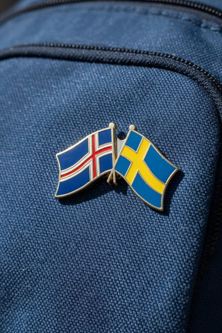 A souvenir enamel pin depicting the flags of Iceland and Sweden