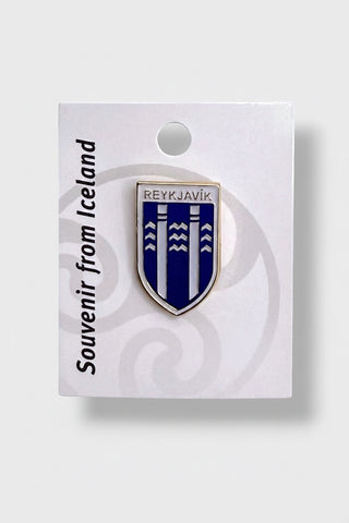 Reykjavík coat of arms enamel lapel pin featuring the official blue and silver city shield on a white souvenir display card