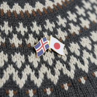 An enamel lapel pin depicting the flags of Iceland and Japan