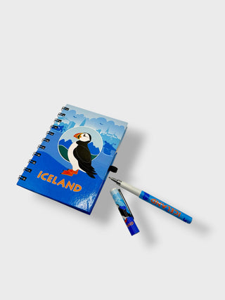 Notebook with puffin design and 'Iceland' text, accompanied by a pen on a white background