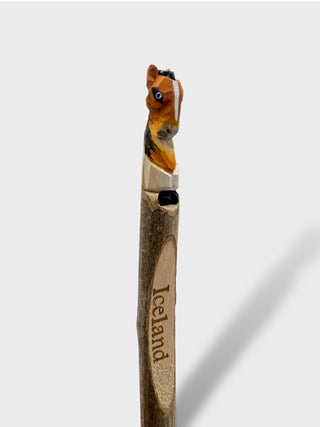 Wooden walking stick with horse head design and 'Iceland' engraving on a white background