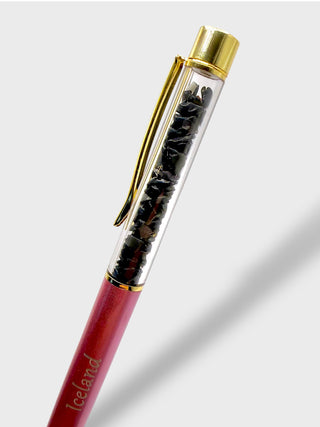 Pen with gold cap and red body on a light gray background