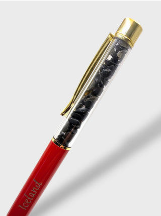 Pen with red body, gold clip, and black accents on a light gray background
