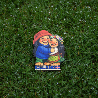 Fridge magnet with two cartoon characters hugging and 'Iceland' written below on a white background
