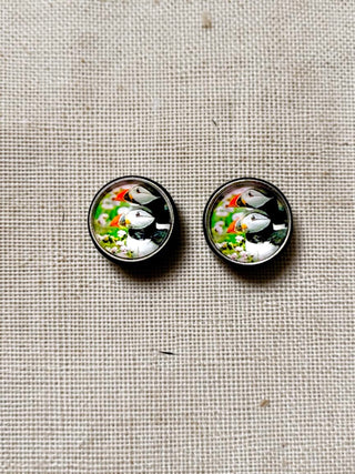 Two round buttons with duck design on a textured fabric background
