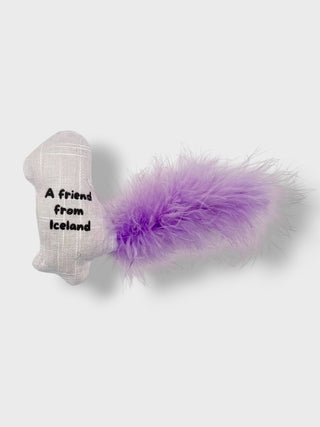 A novelty dog toy shaped like a white knit boot with black text reading 'A friend from Iceland' and attached to a fluffy purple feather tail, shown on a light gray background.