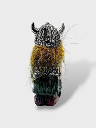 A small Viking figurine shown from the back, featuring a horned helmet, dark green tunic, brown beard, and dark base, photographed on a light gray background.