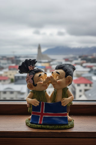 Hand-painted polyresin Icelandic troll couple kissing while holding the Icelandic flag, wearing traditional-style outfits, 12 cm (4.72 in) tall.

