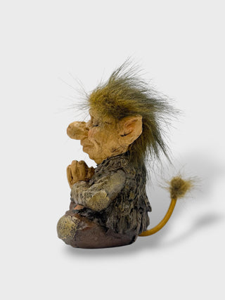 Hand-painted polyresin meditating Icelandic troll figurine sitting cross-legged with folded hands, closed eyes, fluffy hair, and a peaceful smile, 11 cm (4.33 in) tall.
