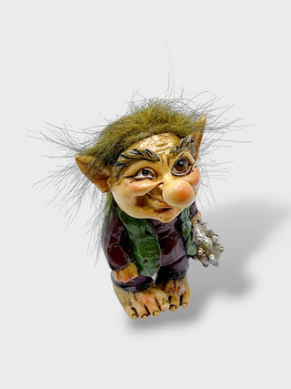 Hand-painted polyresin Icelandic troll figurine holding a sea shell, wearing a purple outfit with a green vest, fluffy hair, and a smiling face, 9 cm (3.54 in) tall.
