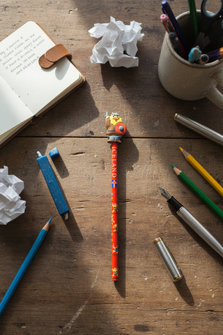 A red pencil decorated with Iceland-themed graphics, featuring a Viking warrior figure holding a shield on top and the word 'ICELAND' printed vertically.