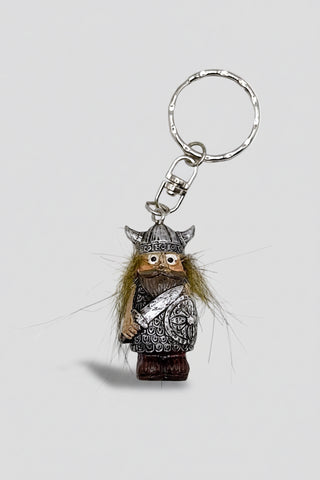 A Viking-themed keychain featuring a small carved wooden figure with a silver horned helmet, brown beard, and silver chain ring, set against a plain white background.