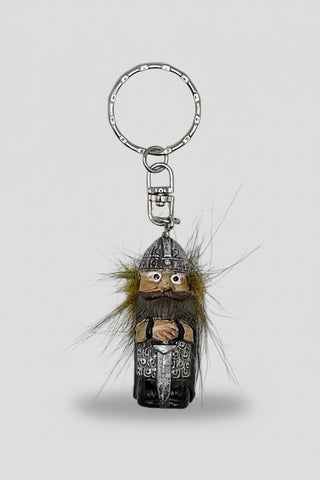 A Viking-themed keychain featuring a small carved figure with a beard, wearing a helmet and armor, with brown and black feathers attached, and a silver metal key ring on a white background.