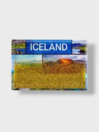 A rectangular souvenir magnet featuring an Iceland landscape collage with a blue 'ICELAND' sign and a large gold glitter field, shown on a light gray background.