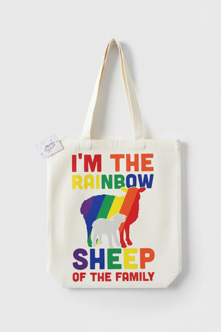 A white canvas tote bag with colorful text reading 'I'M THE RAINBOW SHEEP OF THE FAMILY' and a rainbow-striped sheep silhouette, shown on a light gray background.