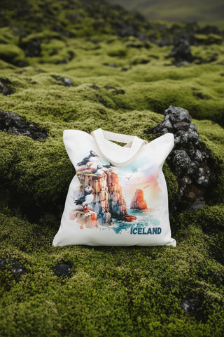 Natural cotton tote bag featuring a watercolor illustration of Atlantic puffins perched on Icelandic sea cliffs above the ocean – reusable Iceland souvenir bag