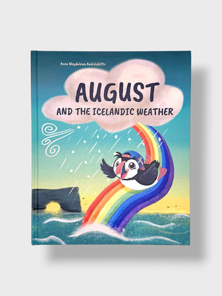 A children's book titled "August and the Icelandic Weather" by Ann Magdallion Robidhltir, featuring a colorful illustration of a puffin under a rainbow and cloud on the cover, shown against a light gray background.
