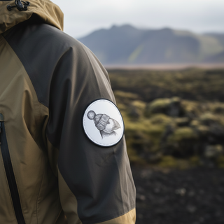 Embroidered iron-on puffin patch wearing a knitted winter hat, round design on white background.