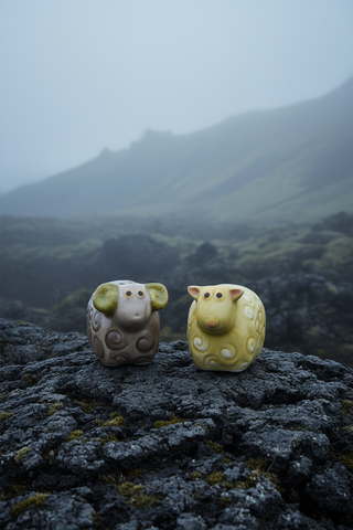 Two ceramic sheep figurines on a white background