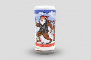 Iceland Yule Lad glass milk cup with colorful winter folklore illustration and snowy mountain background, Iceland souvenir drinking glass.
